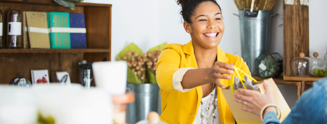 woman in yellow blazer smiling at cash register